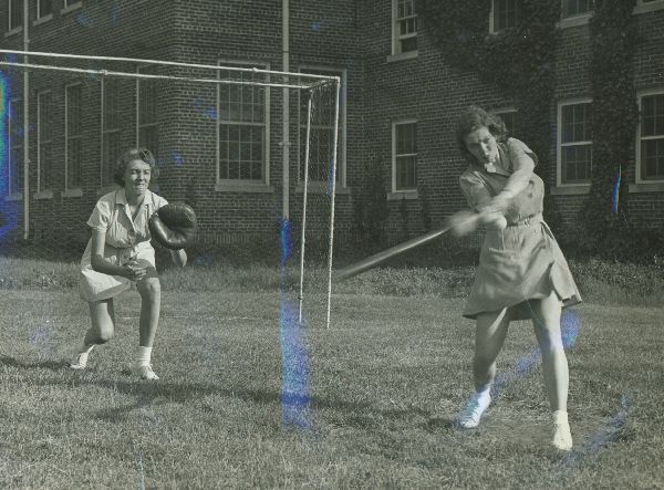 Hollins University students playing baseball.