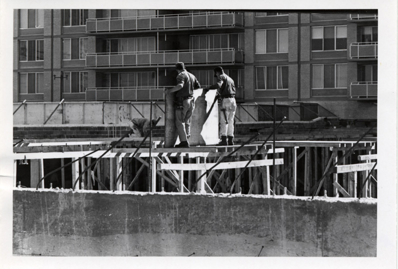Two workmen at Crystal Plaza, on concrete building forms. Date: October 23, 1967. Photographer: Unknown, but worked for Arlington County.