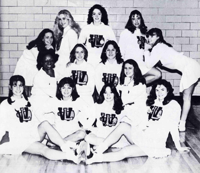 Yearbook photograph of Washington-Lee High School varsity cheerleading squad. Actress Sandra Bullock in seated at lower left, in pigtails. Date: 1982.