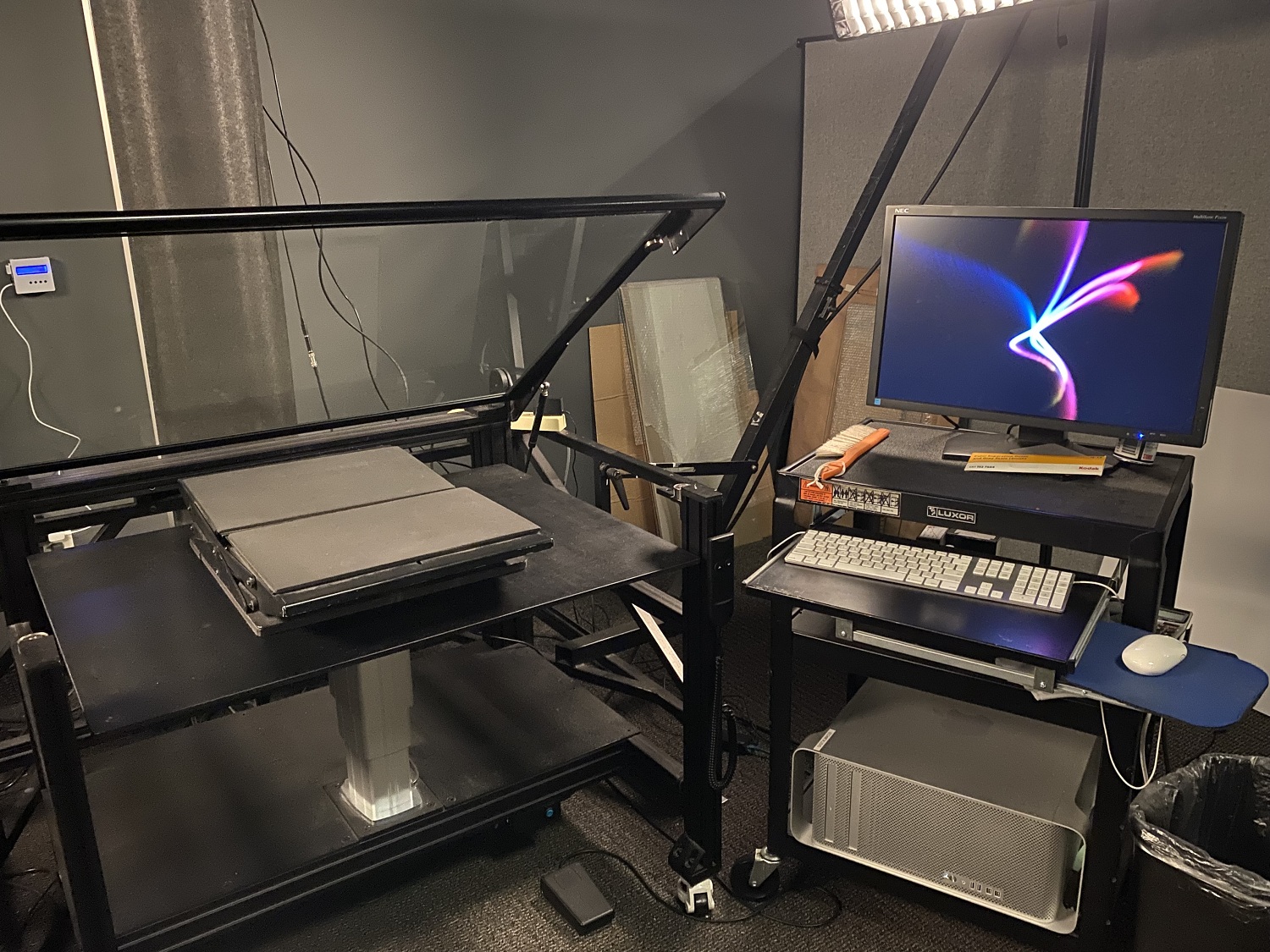 Left image: Open woodruff drawer pulled open with bundled material  Right image: person using a tacking iron to smooth down and flatten a document