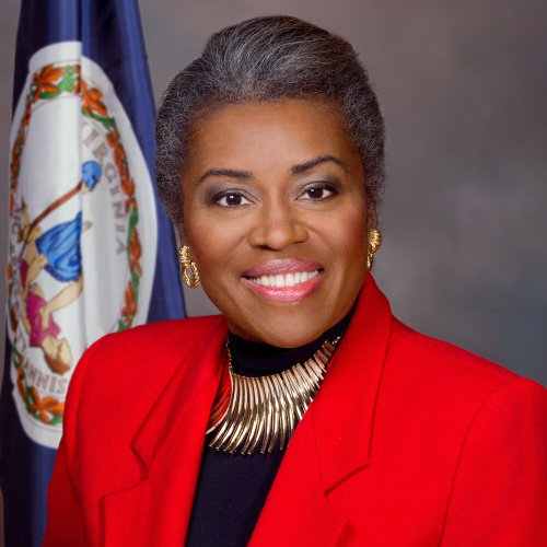 African American woman in a red blazer in front of Virginia state flag