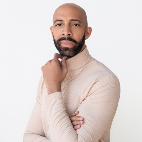headshot of an African American man wearing a white sweater