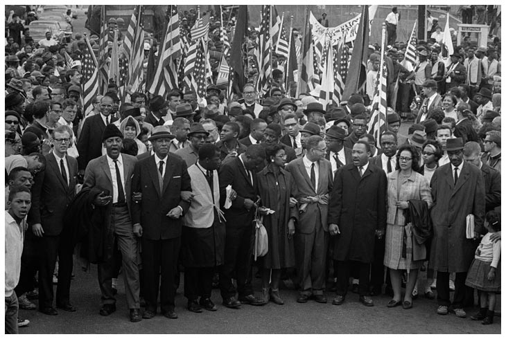 Black and white image of Martin Luther King marching with a crowd
