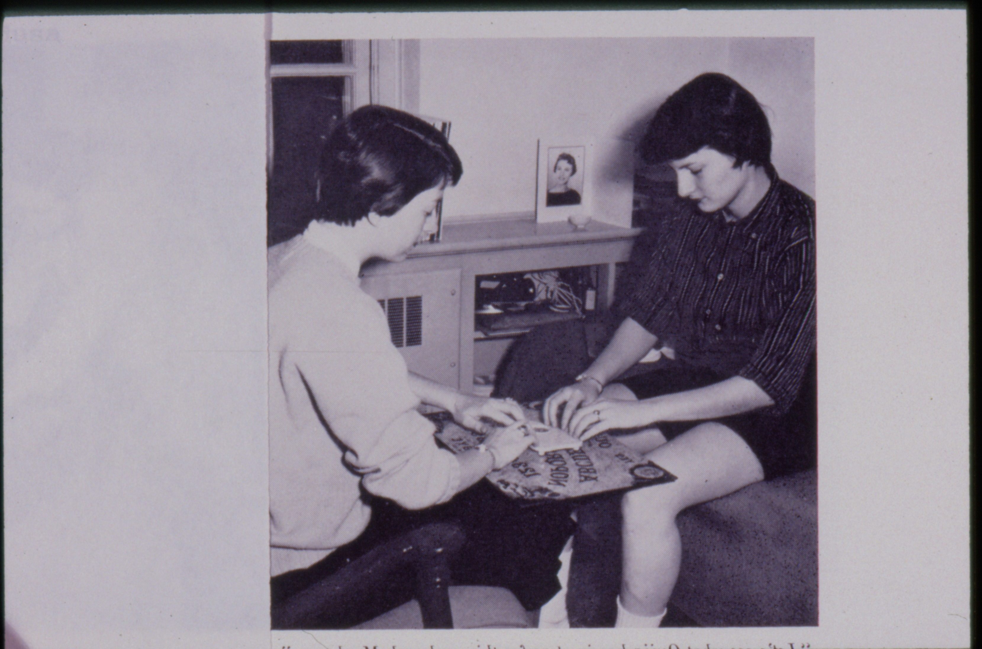 black and white photograph of women in college gathered around an Ouija board