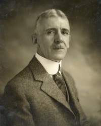 Headshot of a white man wearing early 20th century attire.