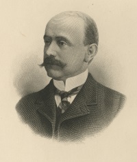 A white man with a mustache wearing late 19th century attire.