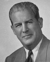 Headshot of a white man wearing a suit and tie.