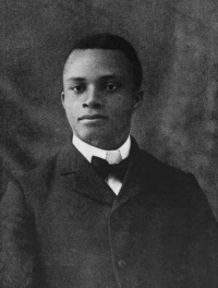 Headshot of an African American man in a suit and bowtie.