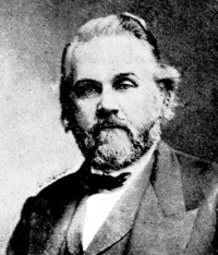 Headshot of a white man with a beard wearing late 19th century attire.