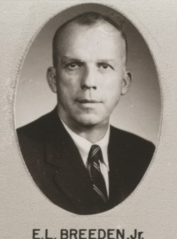 Headshot of a white man wearing a suit and tie.