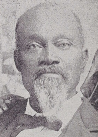 African American man with a mustache and goatee wearing late 19th century attire.