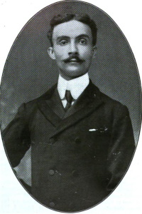 African American man with a mustache wearing an early 20th century suit.