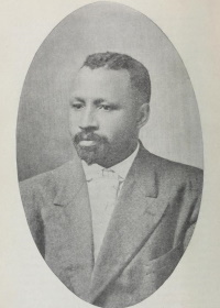 Headshot of an African American man wearing a suit.
