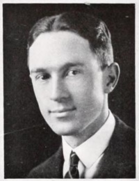 Yearbook photo of a young white man in a suit and tie.