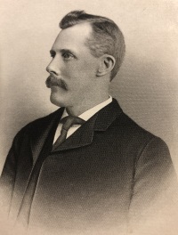 Side view portrait of a white man with a mustache wearing early 20th century attire