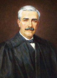 Oil portrait of a white man with a mustache wearing judicial robes.
