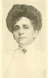 Headshot of a white woman wearing late 19th century attire.