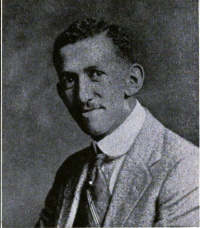 Headshot of an African American man with a mustache wearing an early-20th century suit and tie.