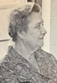 Side view photograph of a white woman wearing mid-20th century attire.