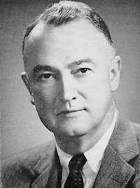 Headshot of a white man wearing mid-20th century attire.