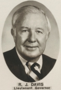 Headshot of a white man wearing late 20th century attire.