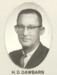 Headshot of a white man wearing glasses and mid-20th century attire.
