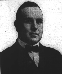 Newspaper photograph of a white man wearing a suit and bowtie.