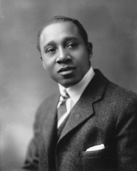 Studio portrait of an African American man wearing an early 20th century suit and tie.