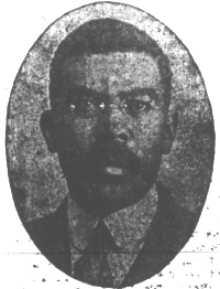 Newspaper photograph of an African American man with a mustache and wearing glasses and early 20th century attire.