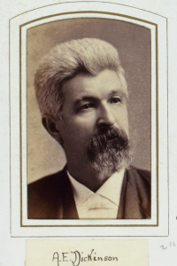Headshot of a white man with a beard wearing late 19th century attire.