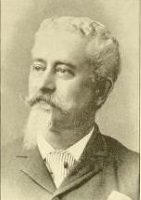 Headshot of a white man with a beard wearing late 19th century attire.