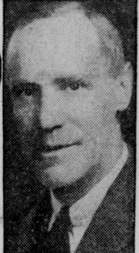 Newspaper photograph of a white man wearing early-20th century attire.