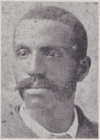 African American man with a mustache and sideburns wearing late 19th century attire.
