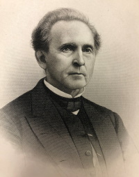 Headshot of a white man wearing a clerical collar.