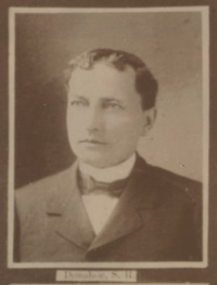 Headshot of a white man wearing late 19th century attire.