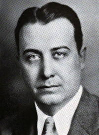 Headshot of a white man wearing mid-20th century attire.