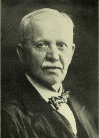 Headshot of a white man wearing early 20th century attire.