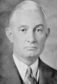 Headshot of a white man wearing mid-20th century attire.