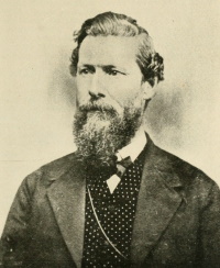 Headshot of a white man with a beard wearing mid-19th century attire.