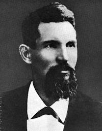 White man with a beard wearing late 19th century attire.