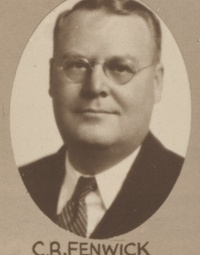 Headshot of a white man with glasses wearing mid-20th century attire.