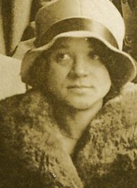 An African American woman wearing a cloche hat and a fun coat.