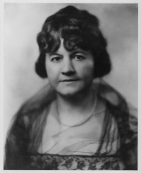 Studio portrait of a white woman wearing early 20th century attire.