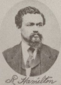 African American man with a mustache and goatee wearing late 19th century attire.