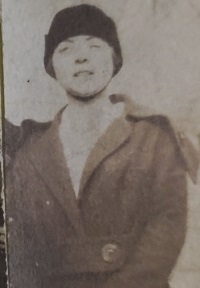 A white woman wearing a cloche hat and coat.