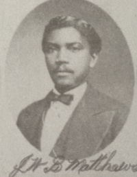 African American man with a mustache wearing late 19th century attire.