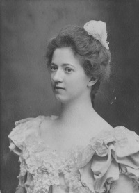 Studio photograph of a young white woman wearing late 19th century attire.