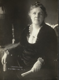 Studio photograph of a seated white woman wearing early 20th century attire.