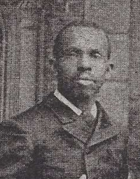 Cropped photograph of an African American man with a mustache wearing late 19th century attire.