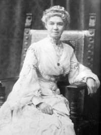 Studio photograph of a seated white woman wearing  19th century attire.